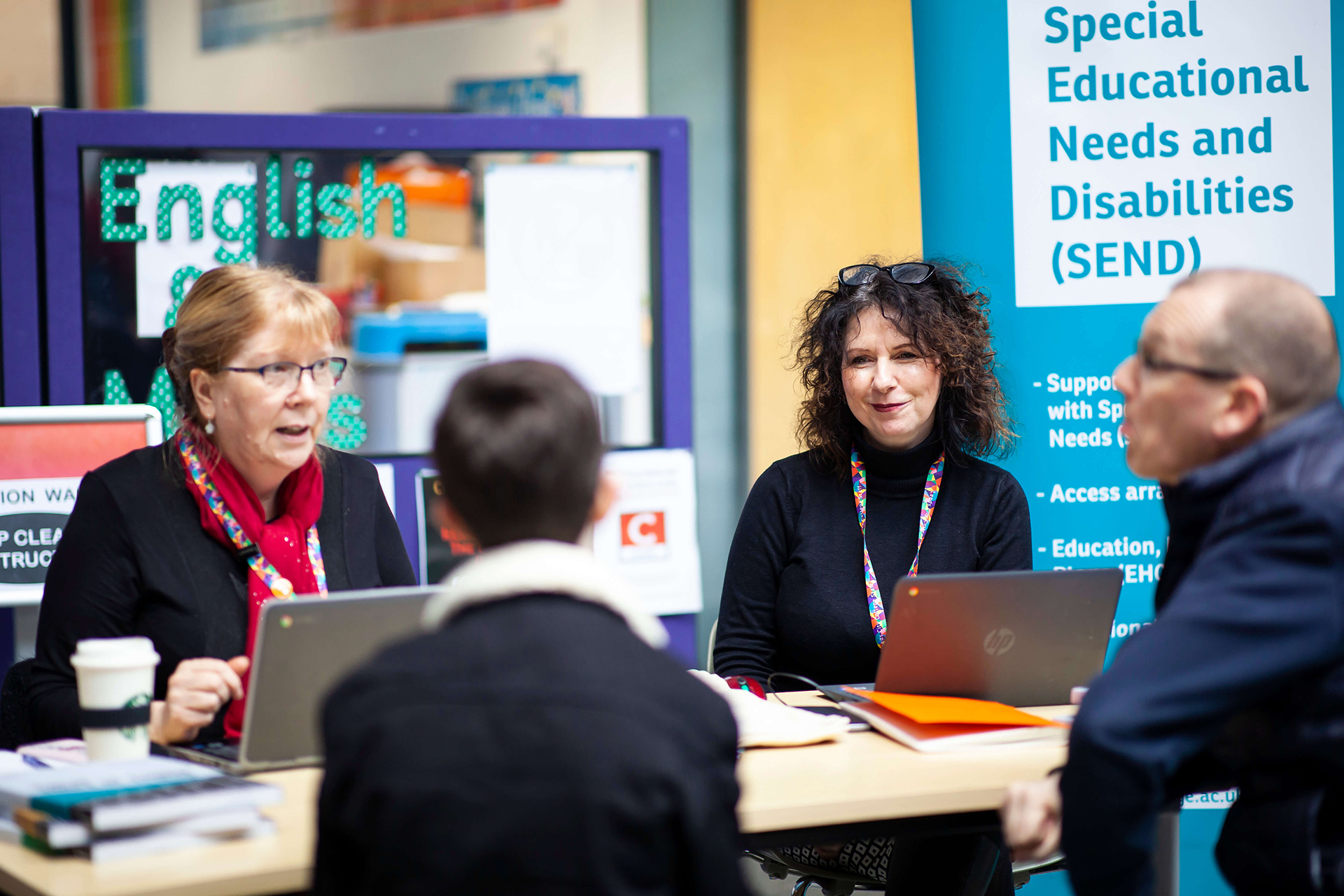 The Special Educational Needs and Disabilities also known as SEND table where two friendly colleagues of Leeds City College are talking to a father and his son