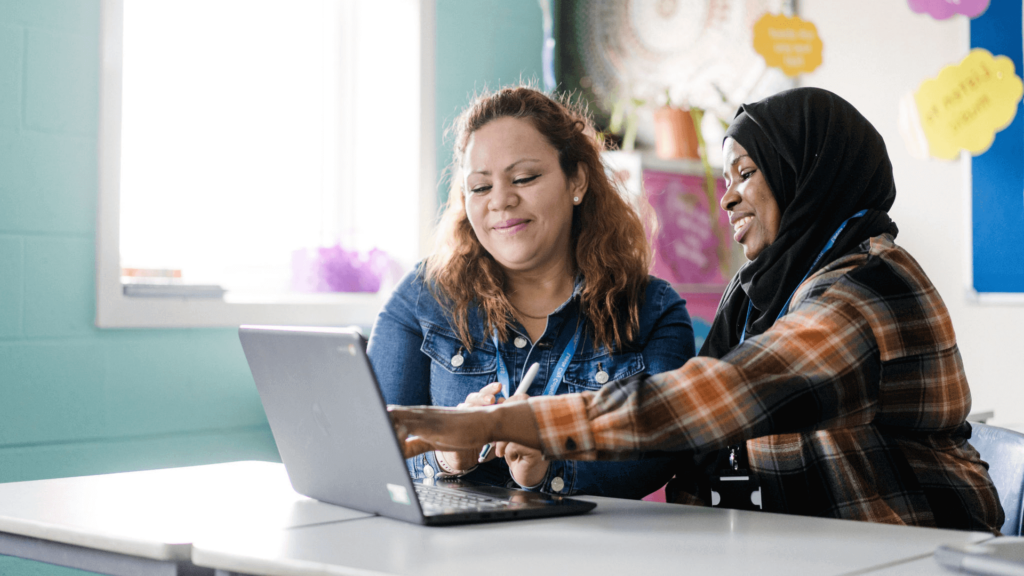 Two adult students working together on a laptop