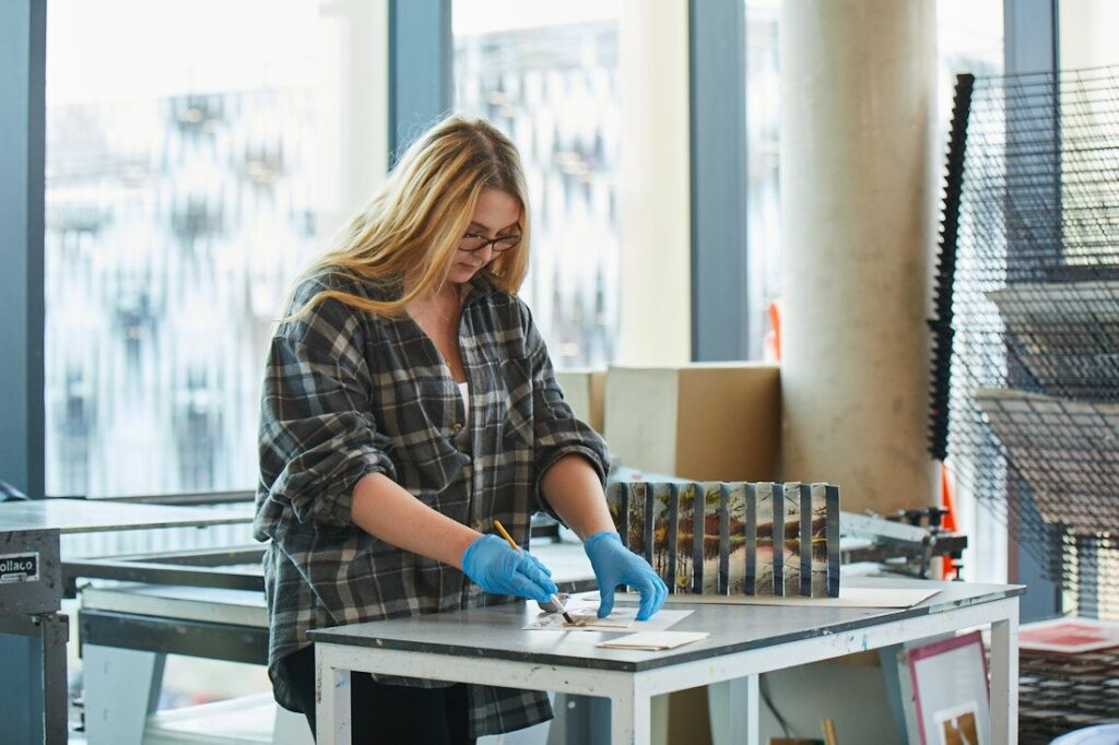 A student creating an art project, painting panels and sticking them together