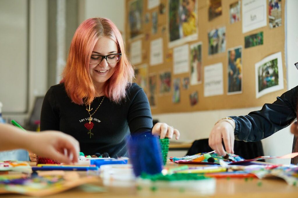 Students on a child education course doing arts and crafts in the classroom