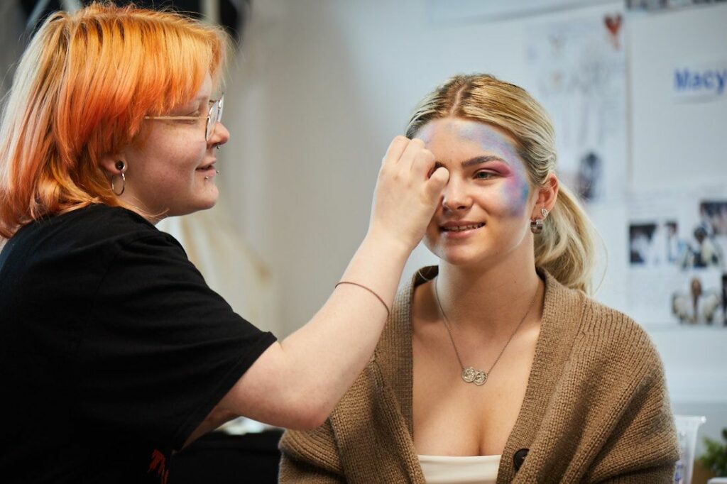 LCC Creative arts student applying theatrical make up to a performer