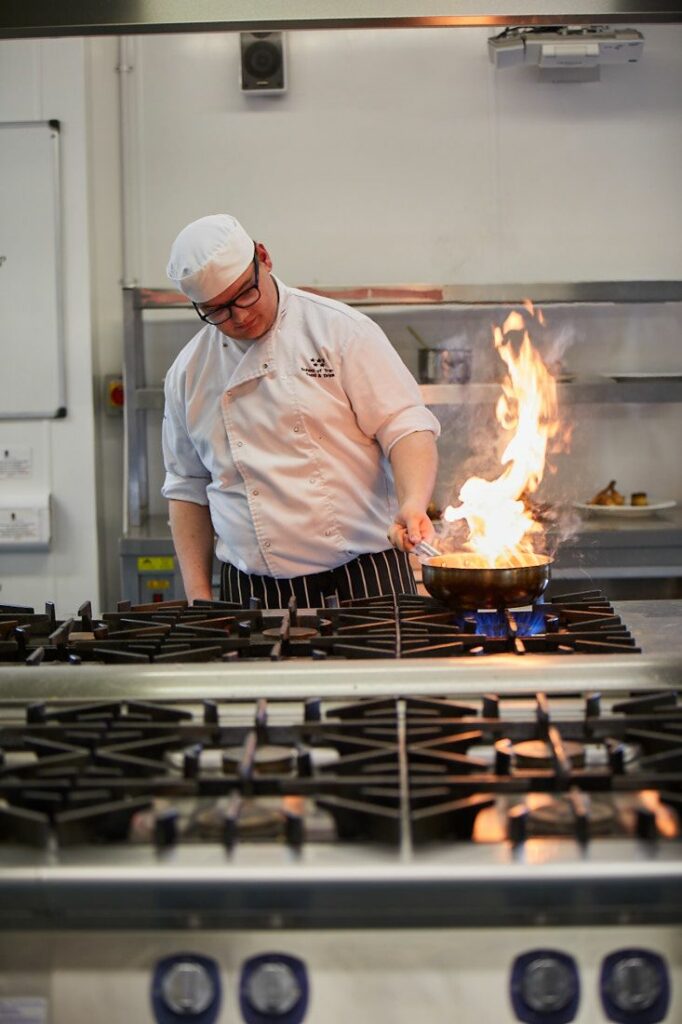 LCC Food and Drink student flame pan frying food