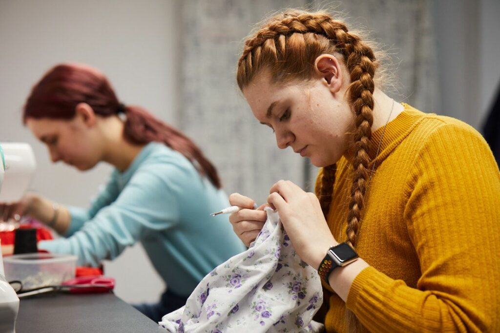 LCC creative arts students working on sewing machines to make clothing