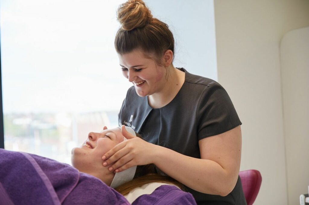 LCC Student in hair and beauty giving a face massage to a client