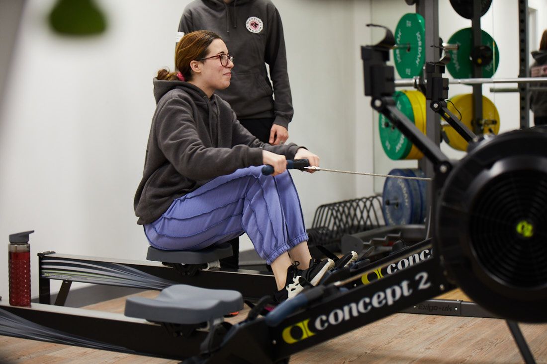 Female student working out on the rowing machine