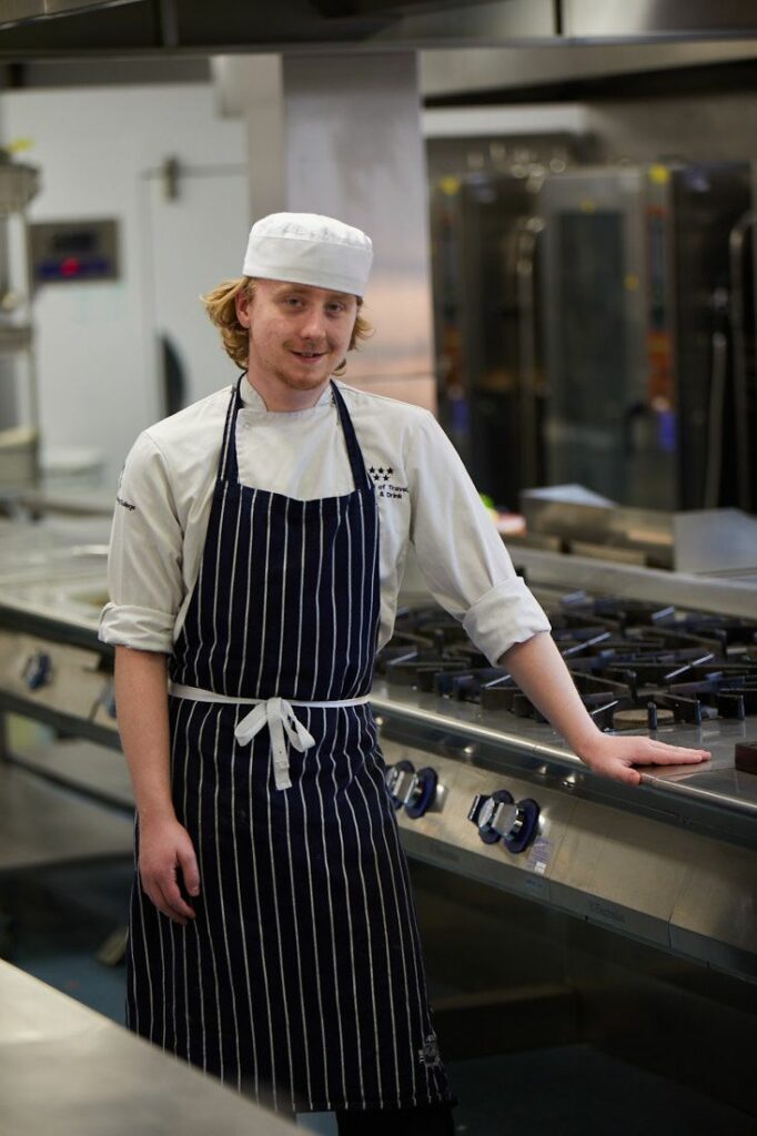 Travel, Food and Drink student standing for a photo in the student kitchens