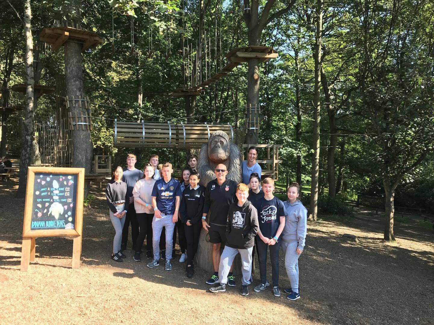 A group of students and tutors standing smiling at the Go Ape Treetop adventure in Temple Newsam