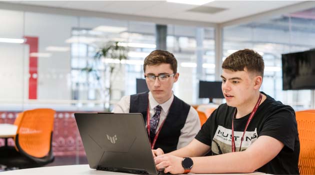 Leeds City College School of Digital and IT students sat at desk working together on a laptop