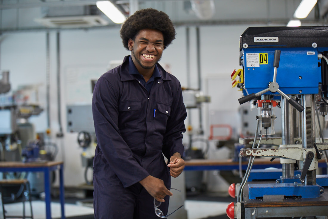 Engineering apprentice at Leeds City College smiling wearing engineering overalls