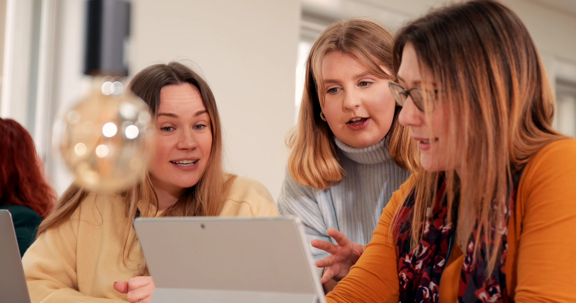 Students and lecturer sitting in the classroom with laptop having discussion