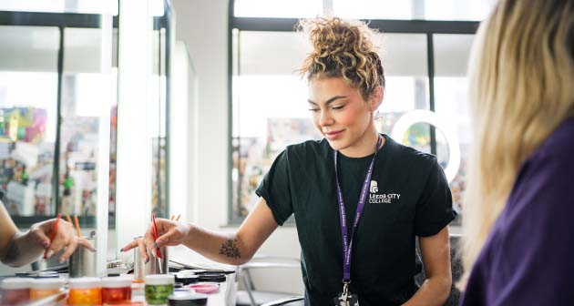 Leeds City College beauty student sat mixing up make up with a beauty brush