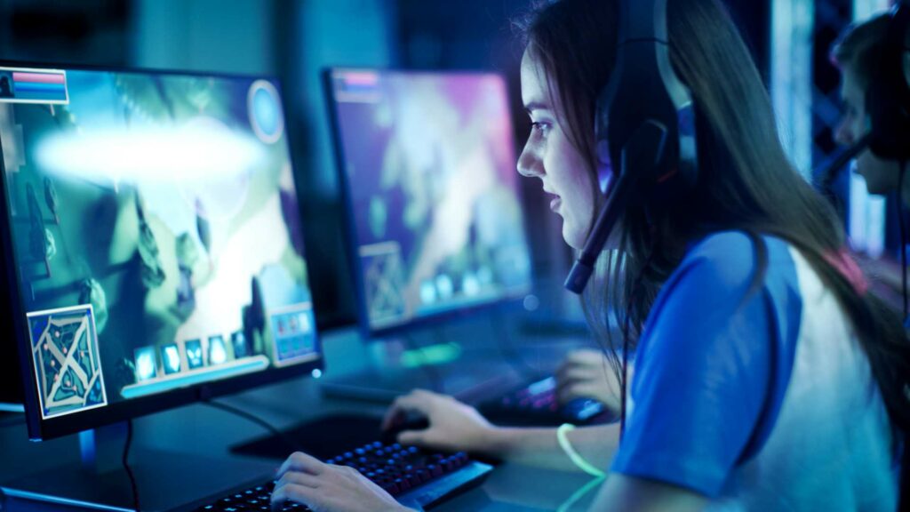 Female esport student playing and focusing on their competitive match with her closely looking at her monitor