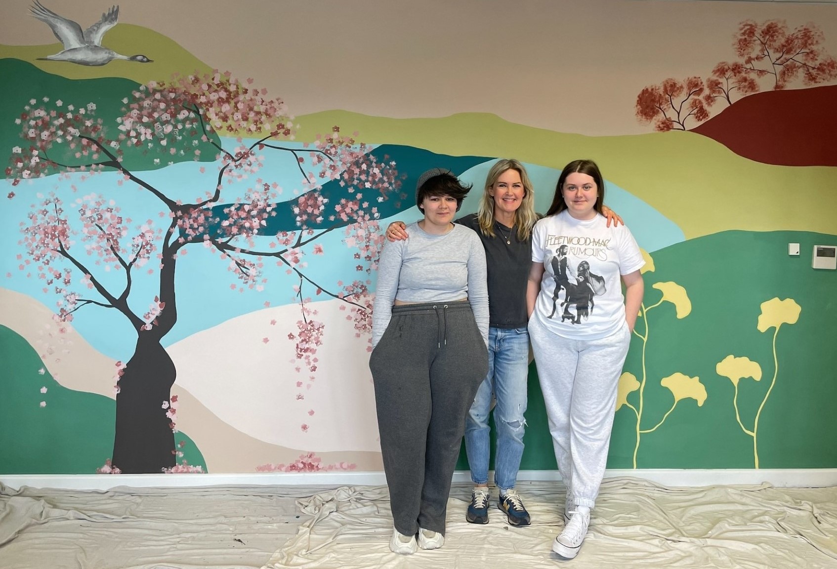 Bear Foley Mitchell, Clare Booker and Lauren Atkinson standing in front of the mural