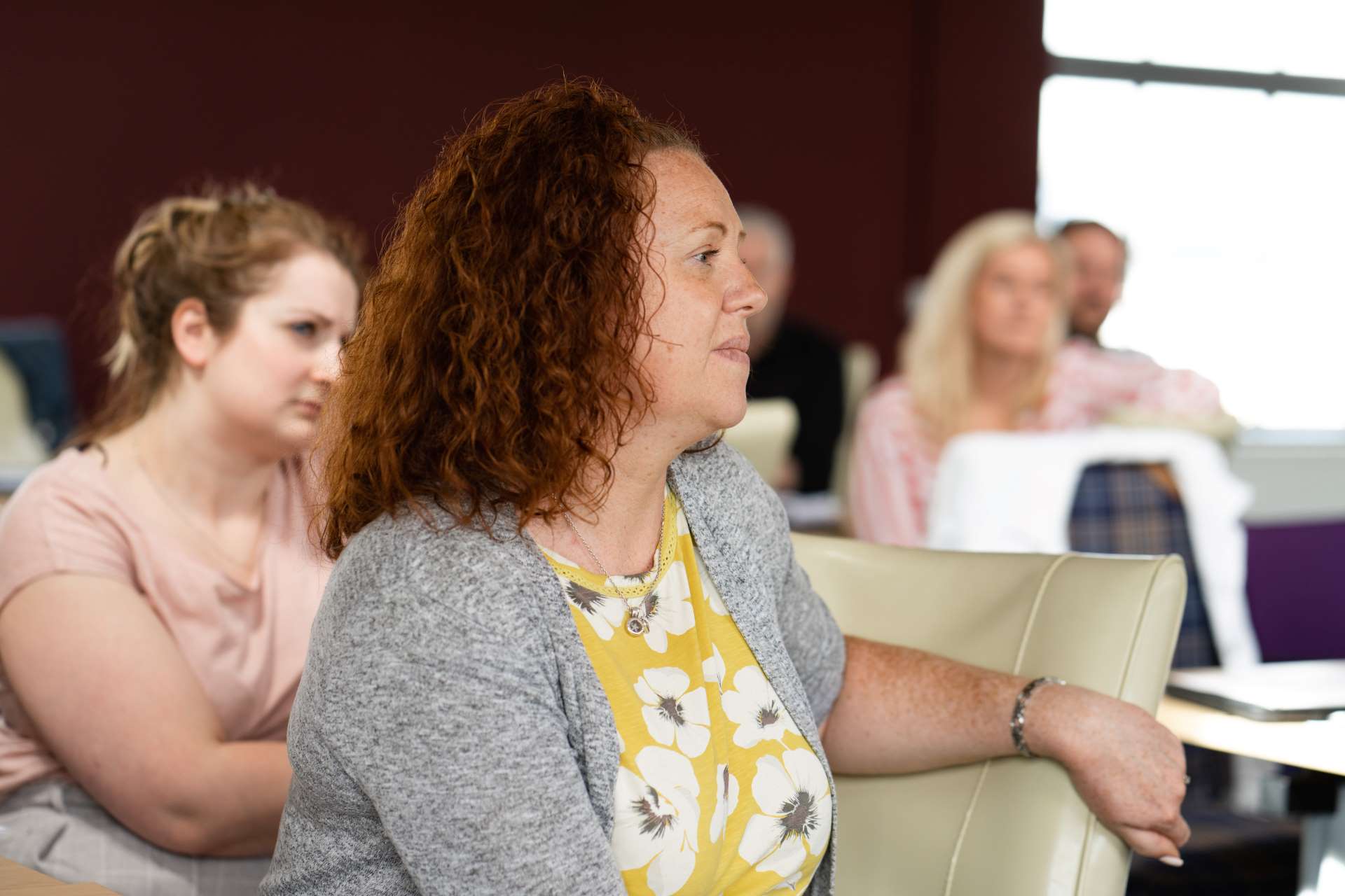 A group of adult learners turning round in their chair to listen to a presentation being given