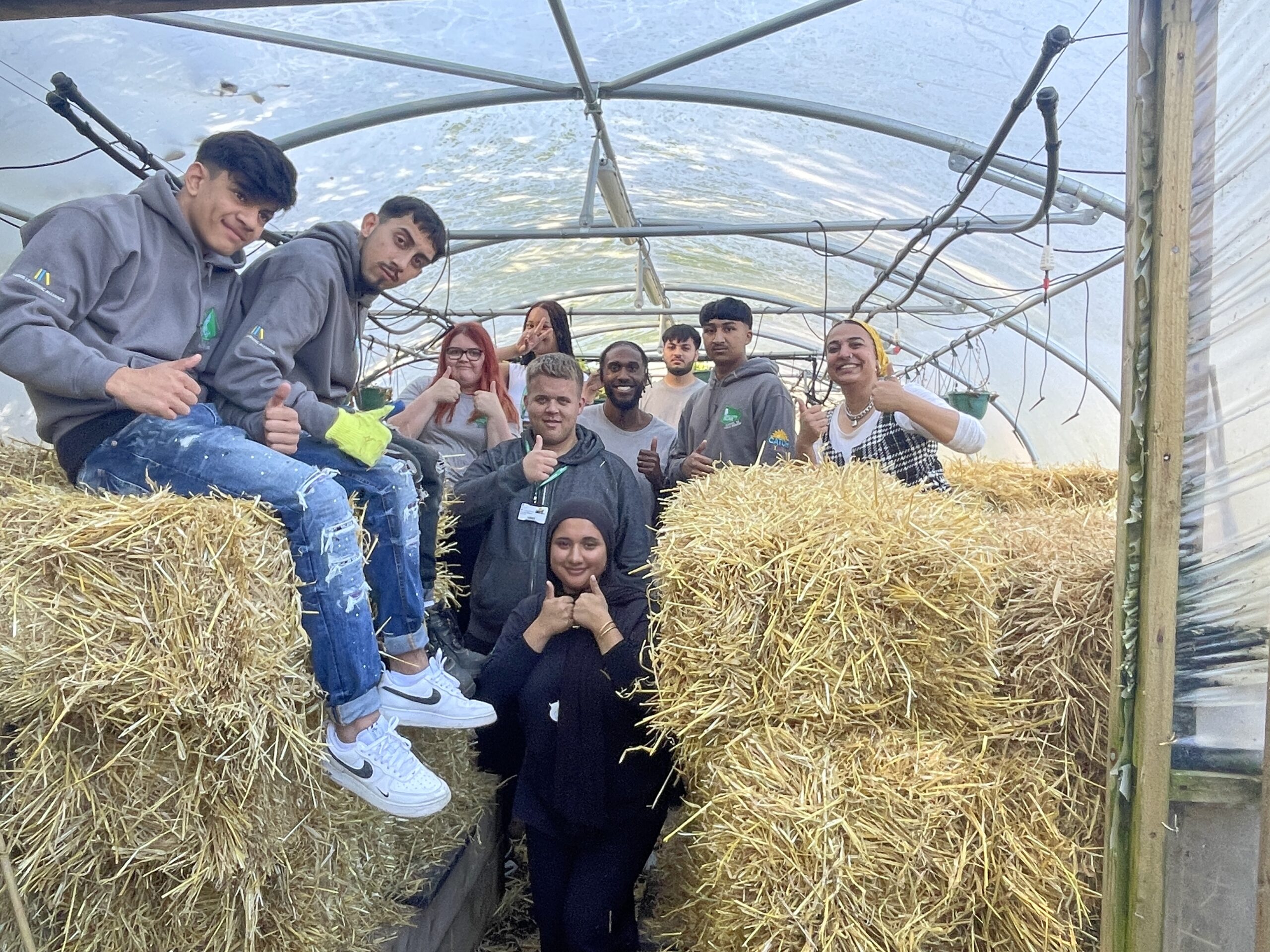 Students in a group photo behind hay bales