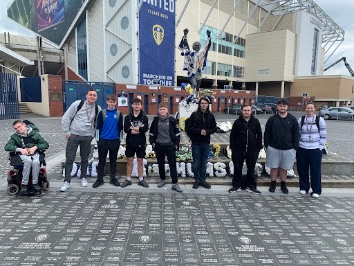 A group of students standing outside a football stadium