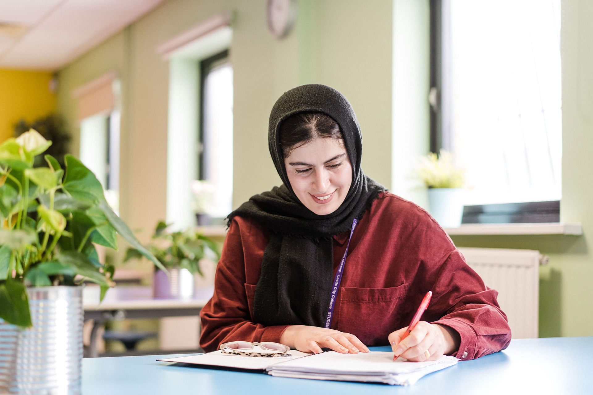 Adult student smiling writing notes sitting in classroom