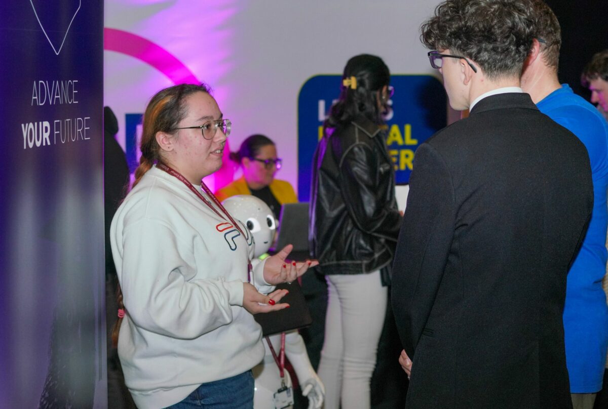 A woman engages in conversation with a man at a social event, showcasing interaction and networking.