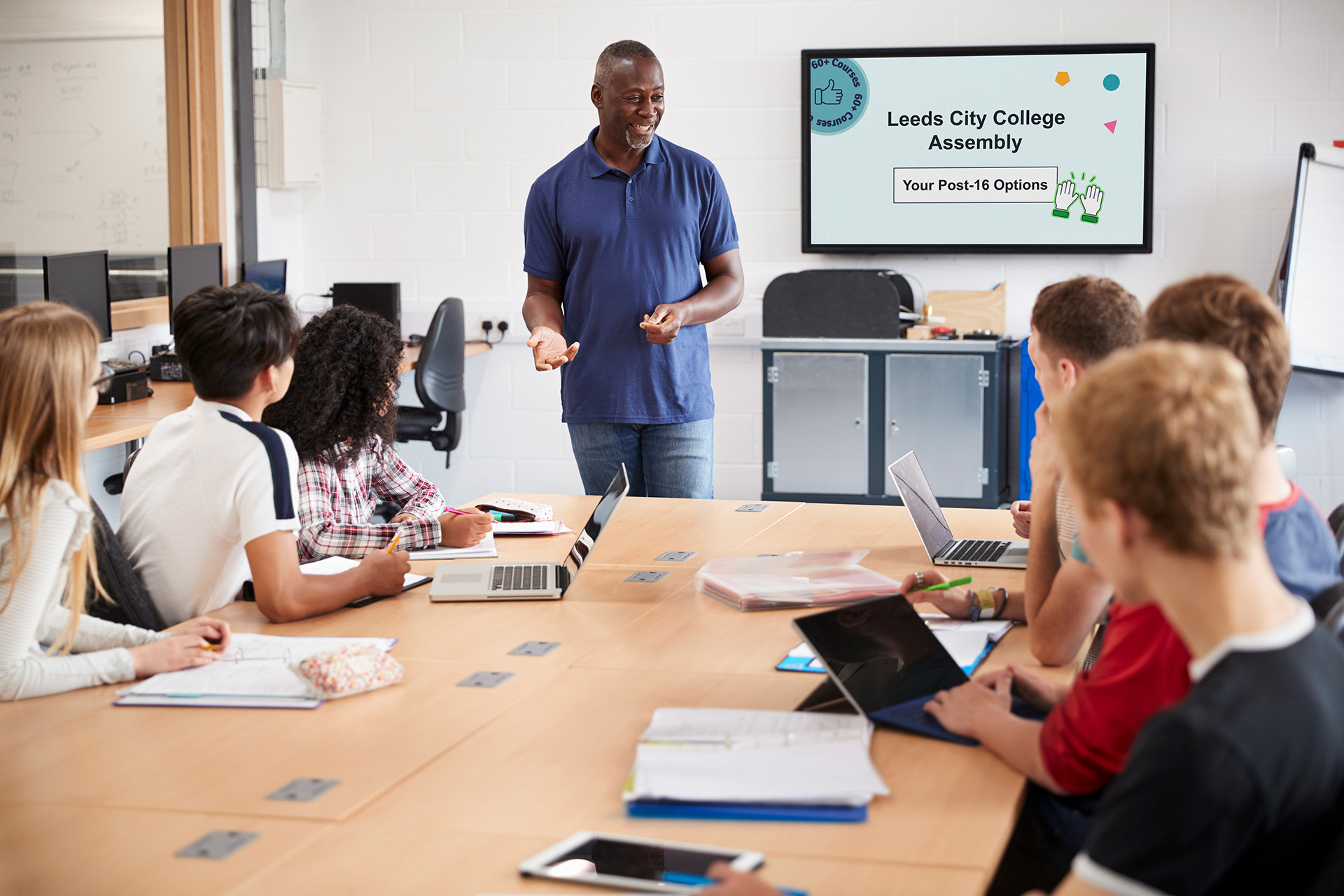 A teacher is delivering a presentation while the students attentively listen and engage in the classroom