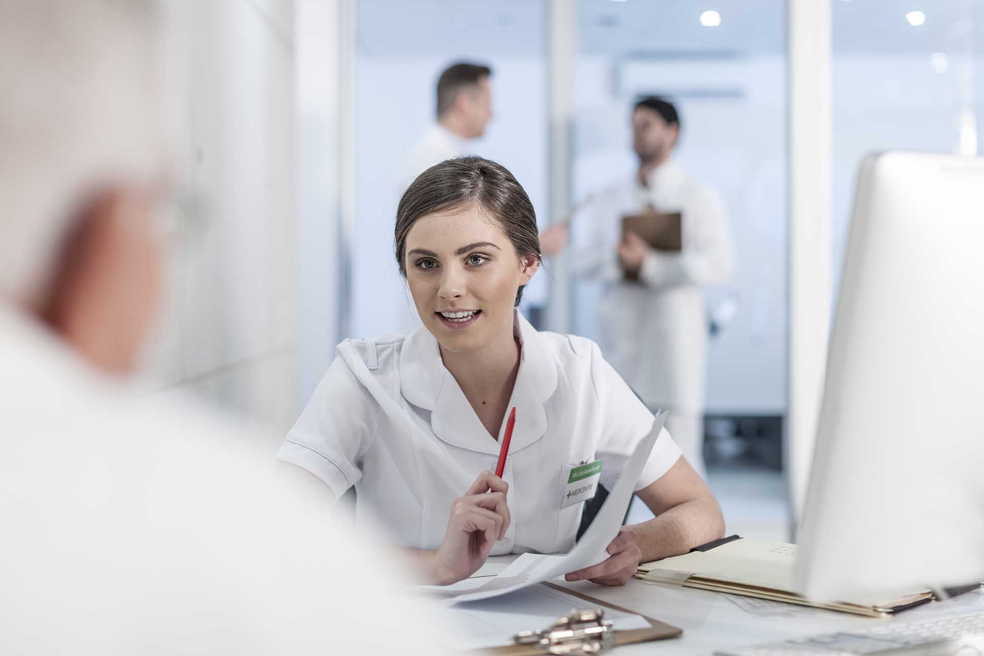 Nurse helping patient at clinic reception