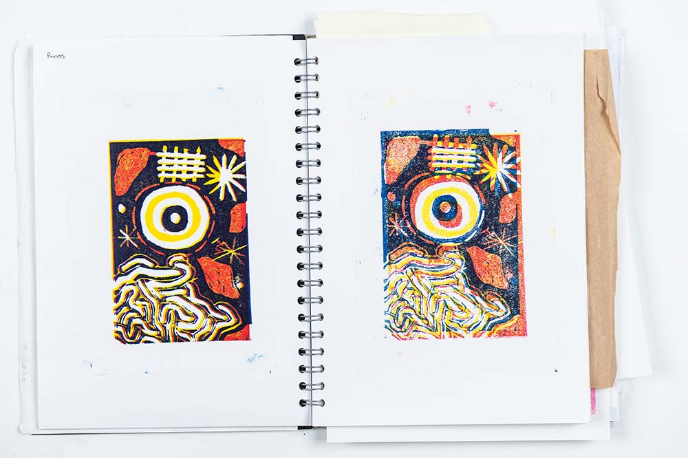 Colourful print work in an art sketchbook by Creative Arts Art and Design student