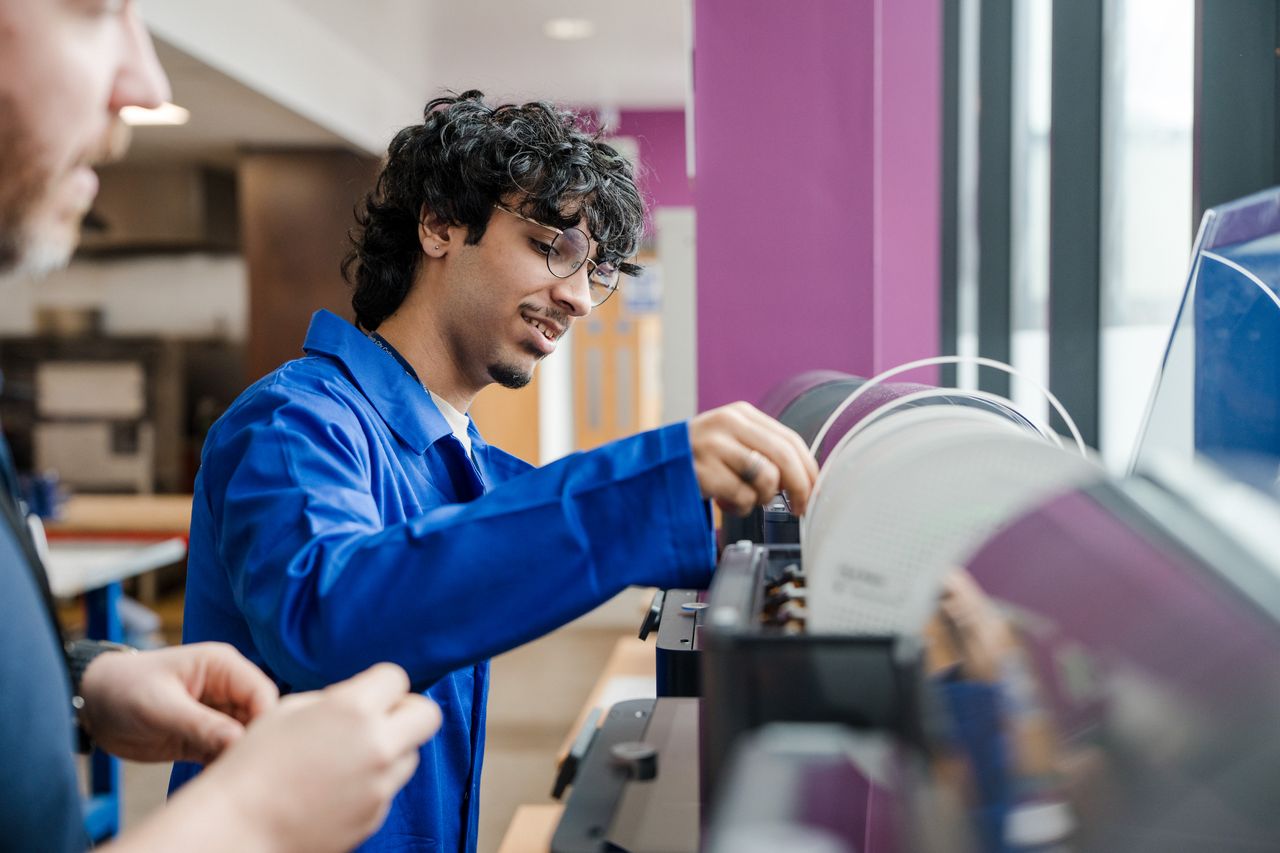 A student replacing the wire used for 3d printing