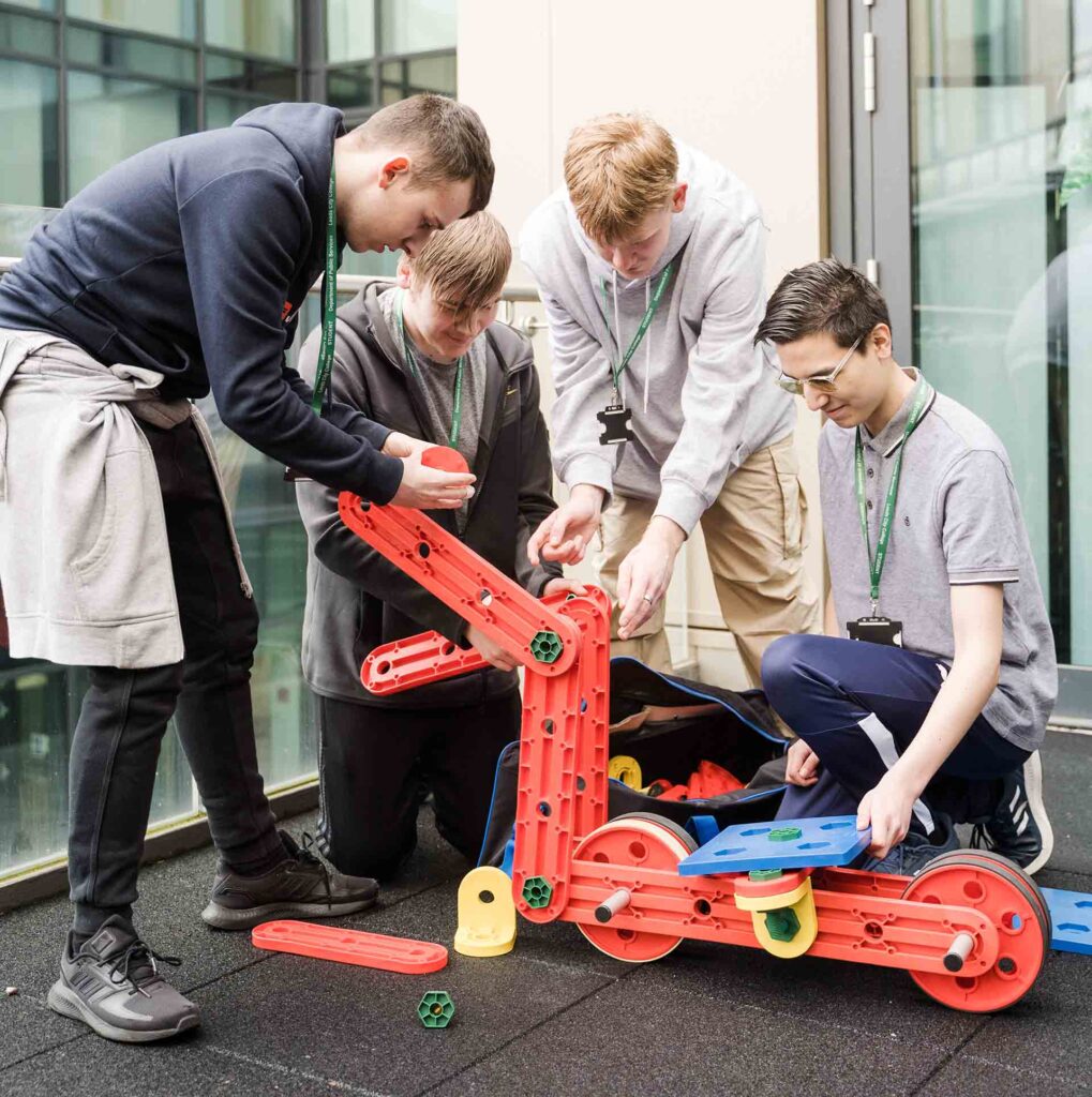 Students assembling scooter model for project outside of Quarry Hill