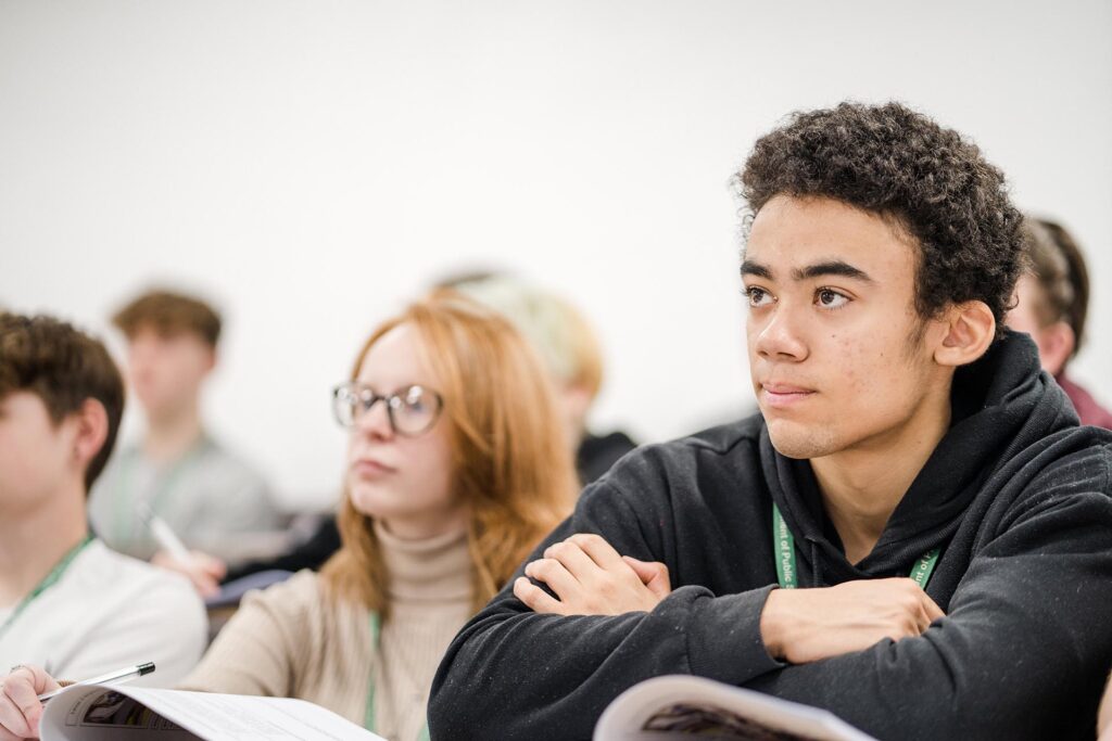 Classroom of students looking to the front of the class listening to the tutor
