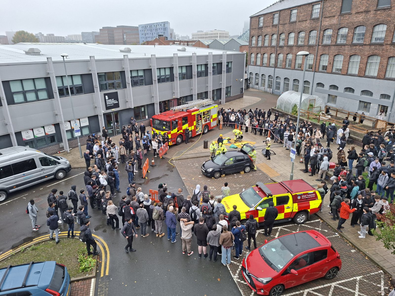 large group of people stood outside with fire ambulances