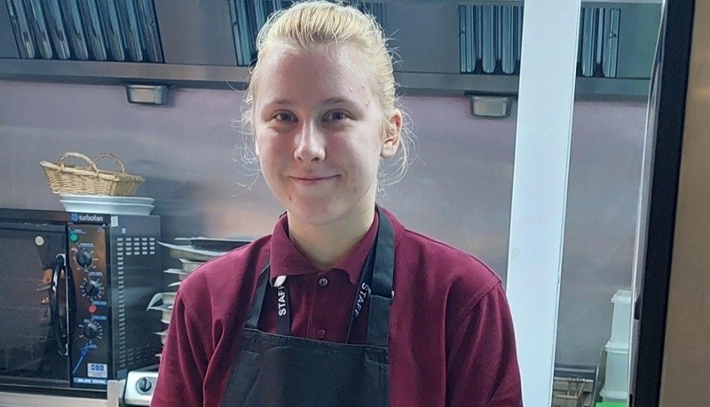 Enjoying her first catering job, at Leeds City College - Lita Leikarte standing behind a serving counter