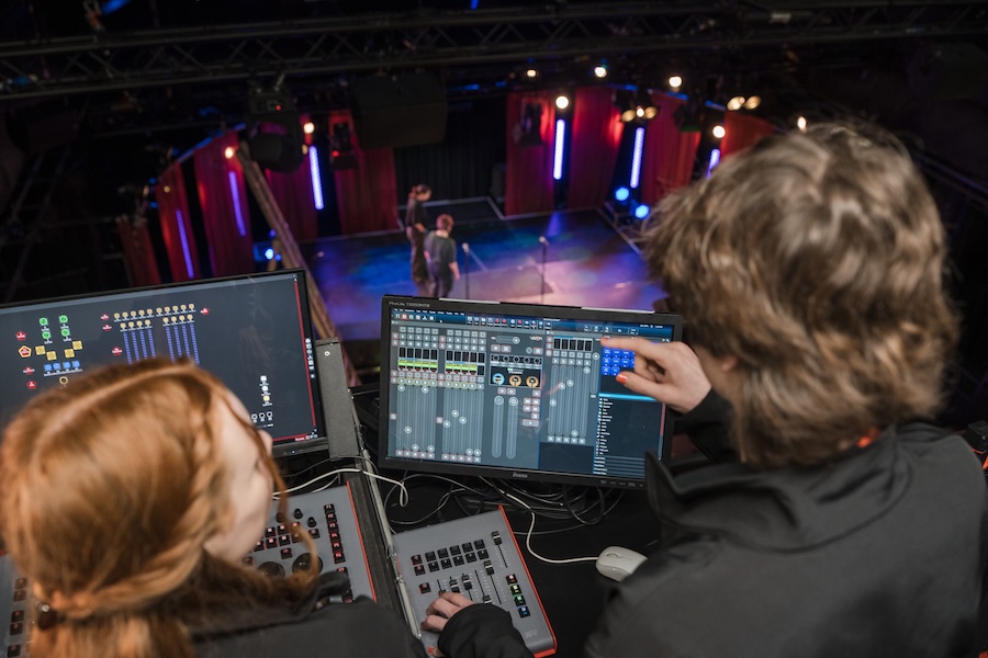 Theatre production students monitoring the sound of a production