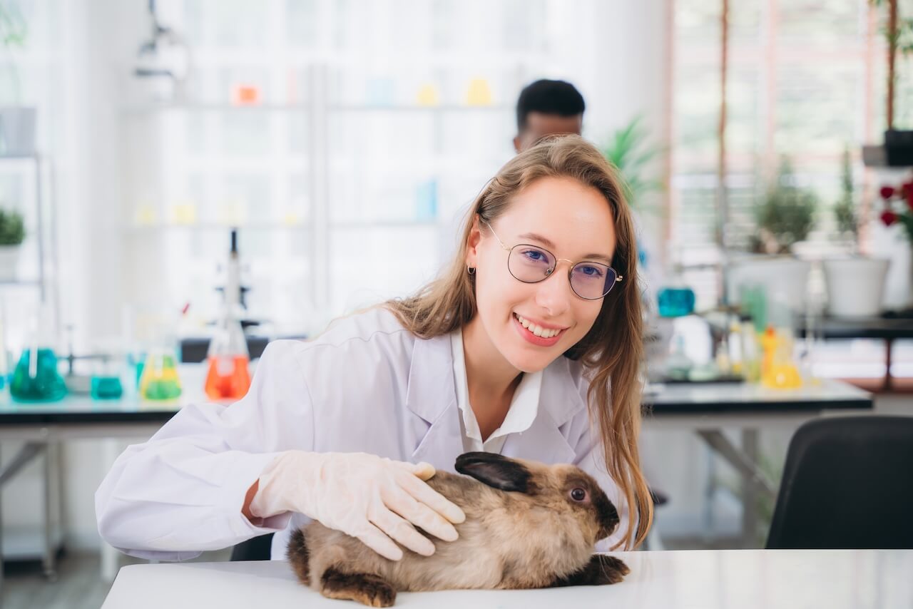 An animal technologist student with a rabbit in the lab