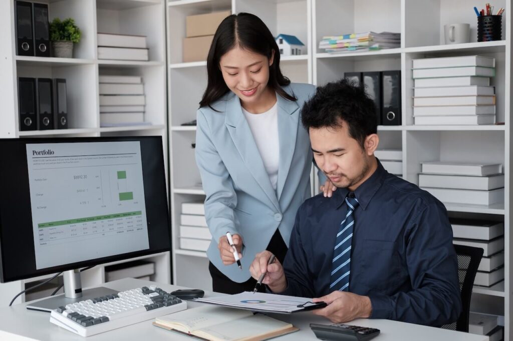 An accounting tutor instructing a student at a desk