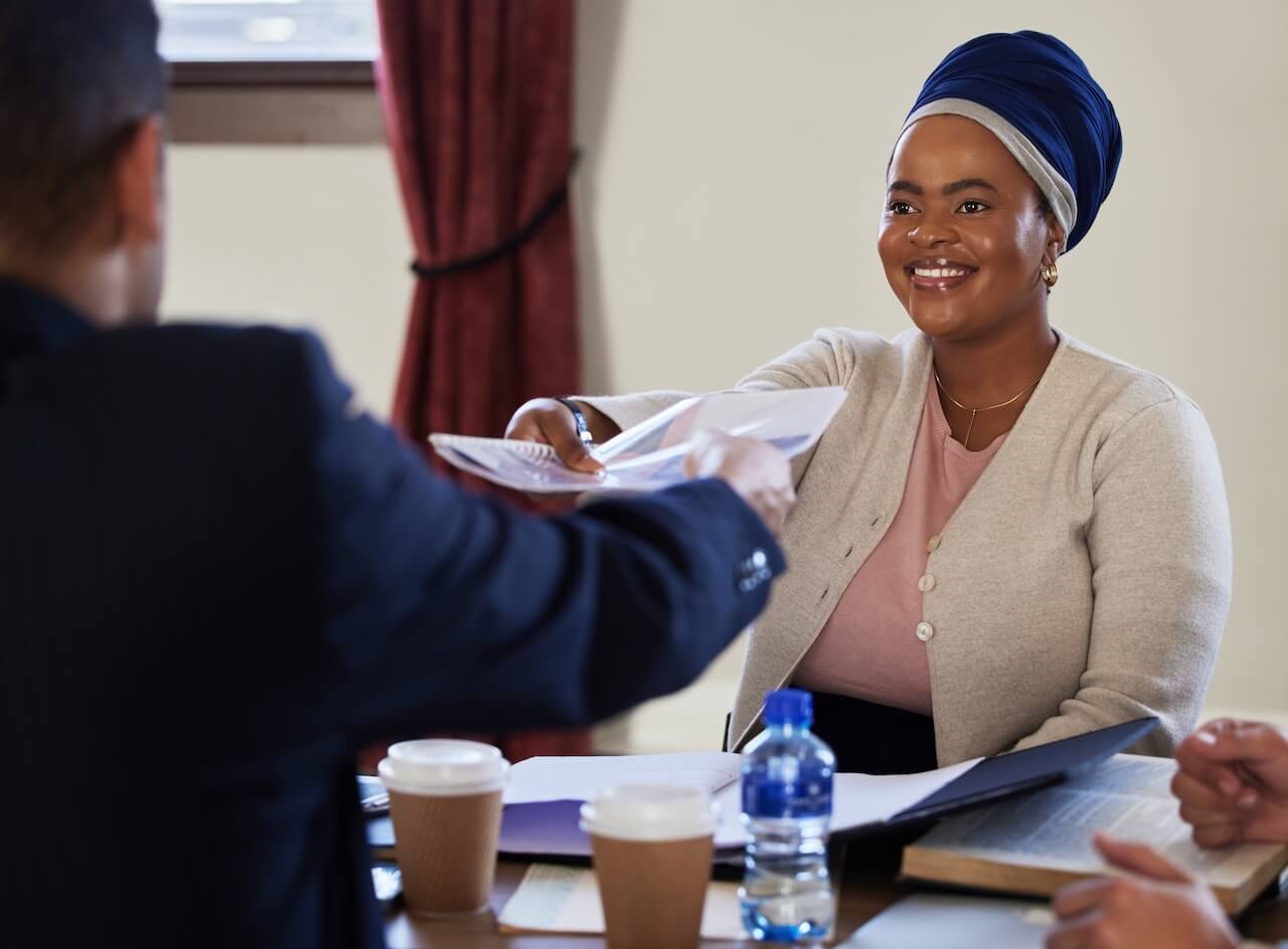 A chartered legal executive being passed documents over a desk