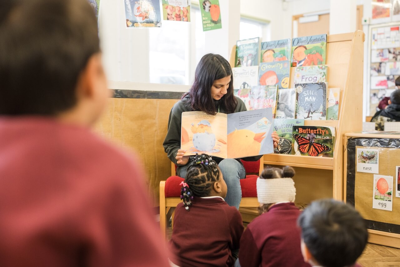 A teacher reading a book out to the class