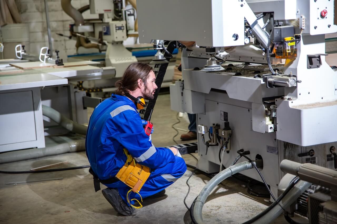 A machining student inspecting a machine