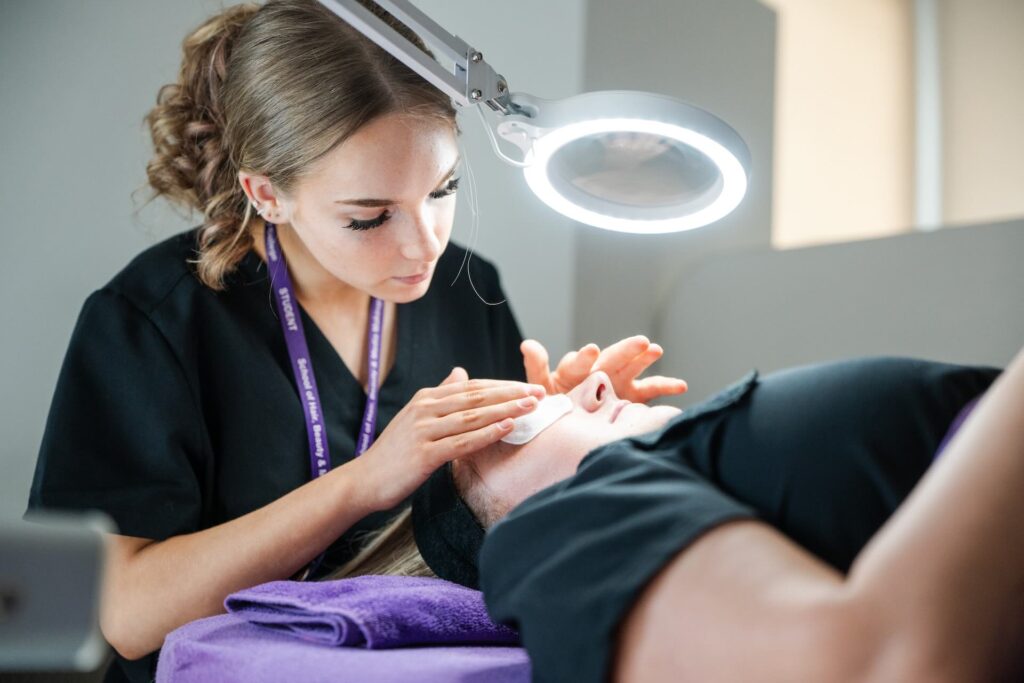Beauty therapy student working on a clients eyes and eyebrows