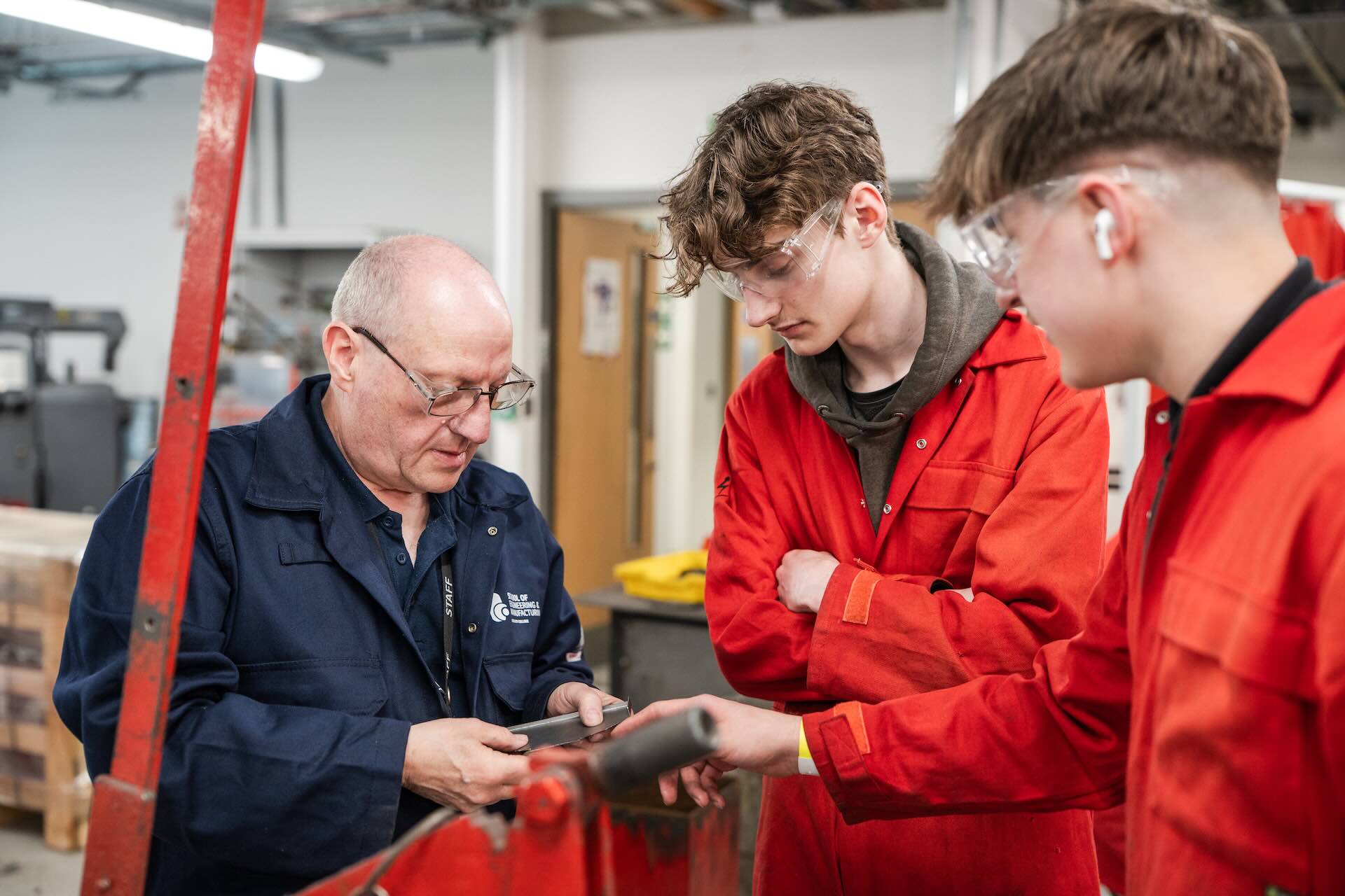 Two Engineering students talking with the teacher