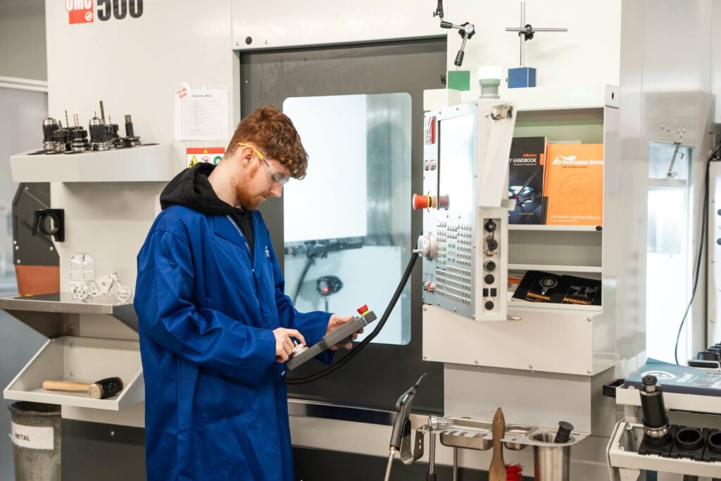 Engineering student using a industrial 3D printer