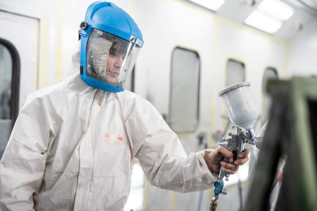 Motor Vehicle student using a spray gun to paint a car