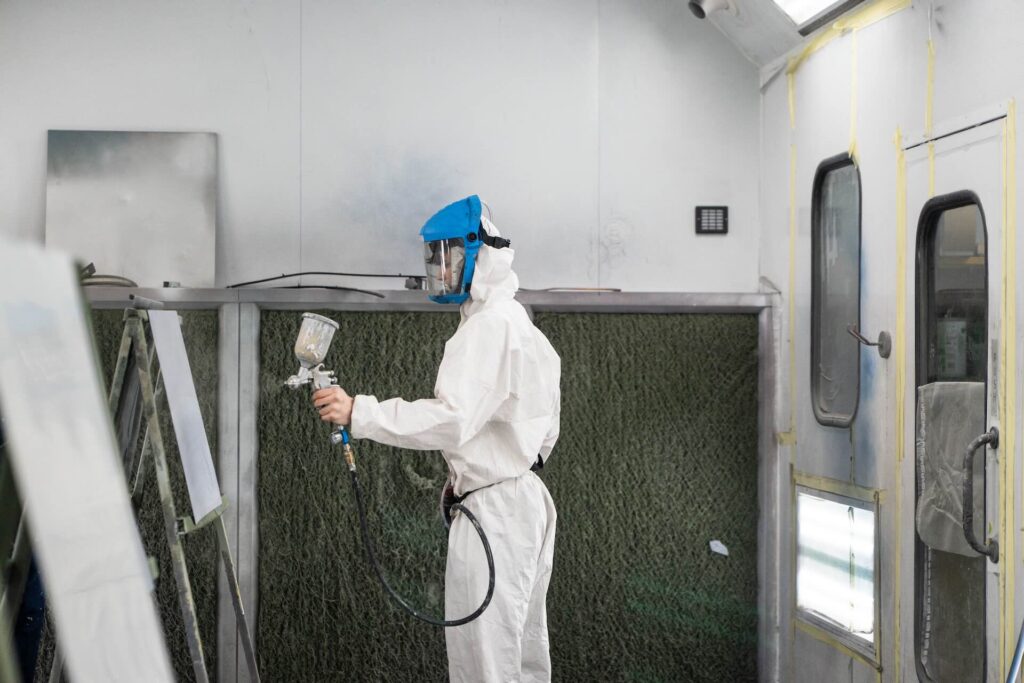 Motor Vehicle student using a spray gun to paint a car