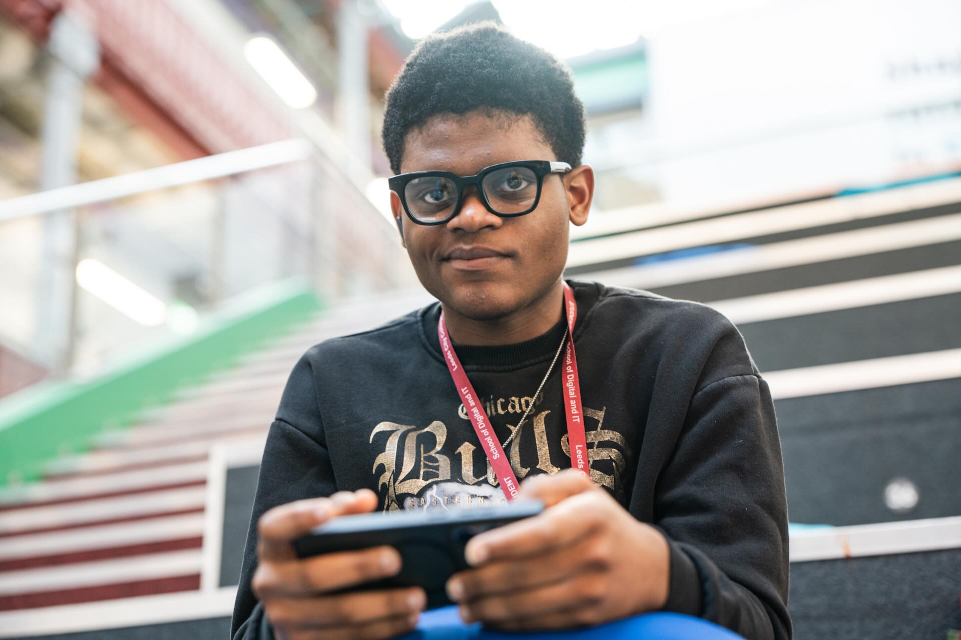Student playing on his phone looking at the camera