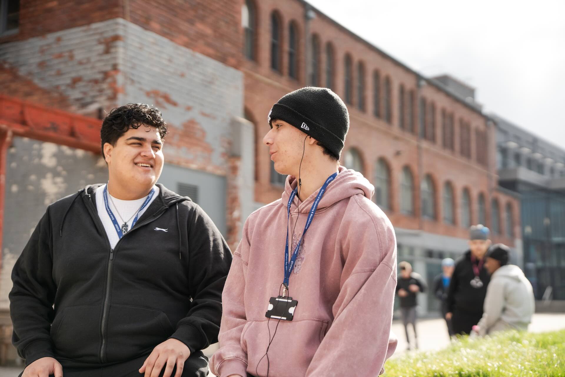 Two students outside socialising with one another
