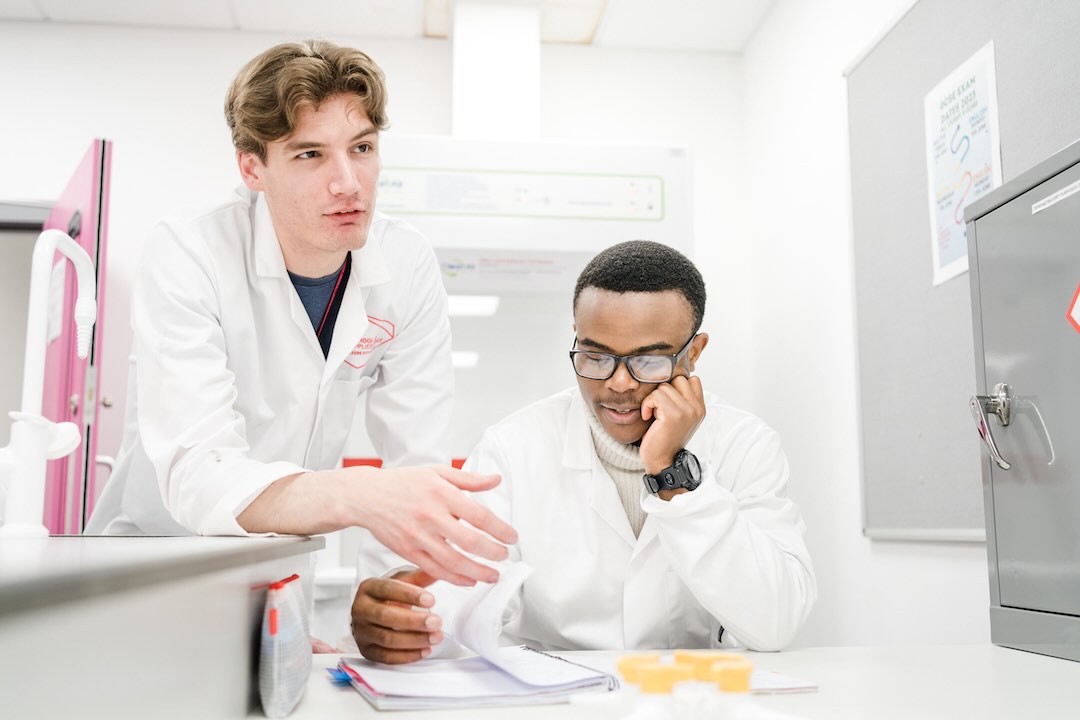 Two science students reviewing notes of the experiment they carried out