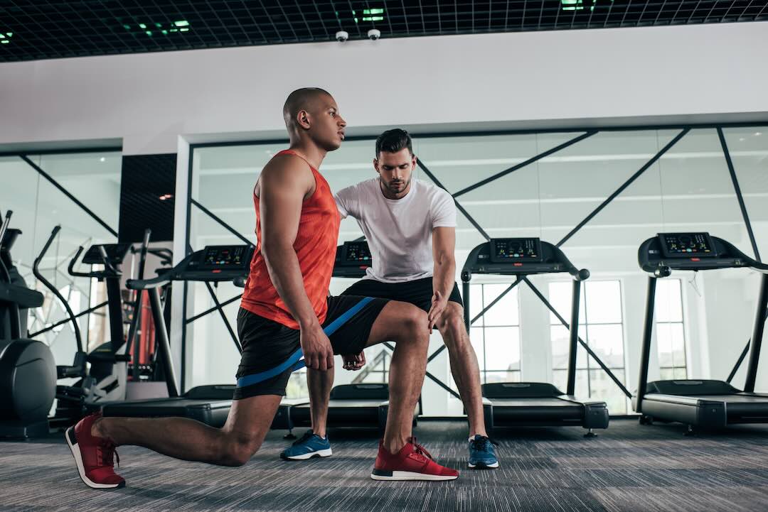 A personal trainer instructing a client to do walking lunges