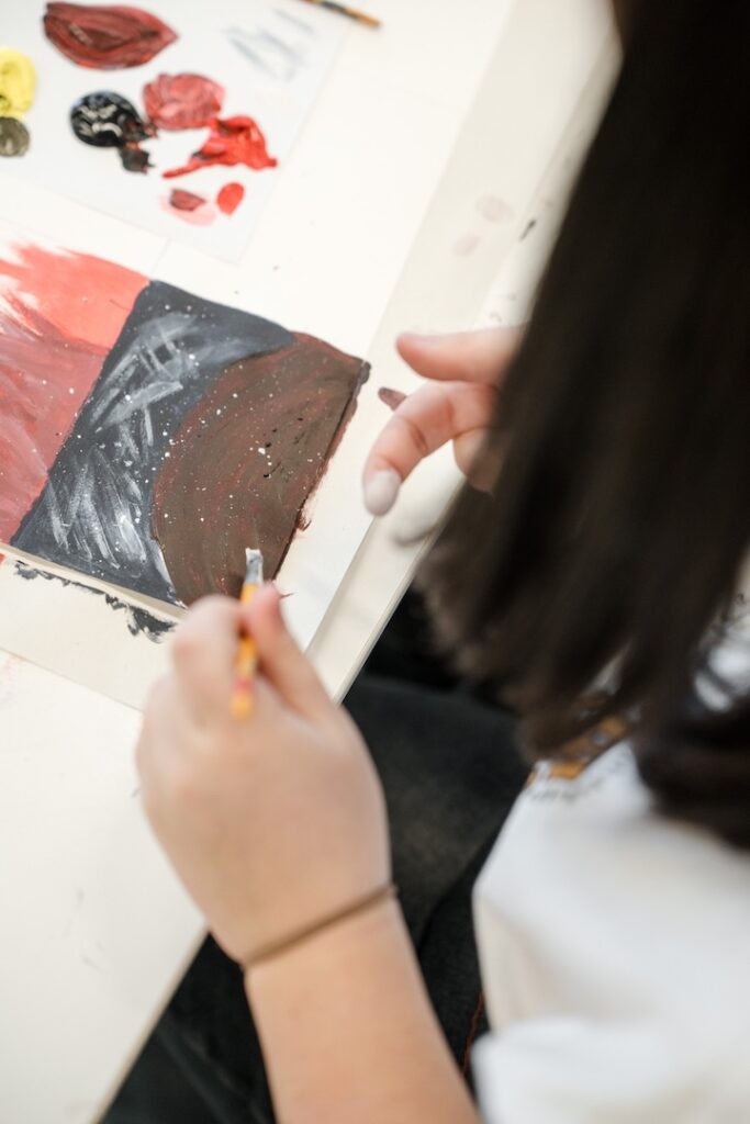 A student painting a dark planet like scene