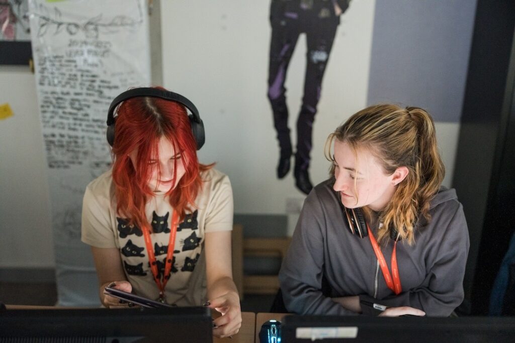 Two students reviewing artwork on a tablet together