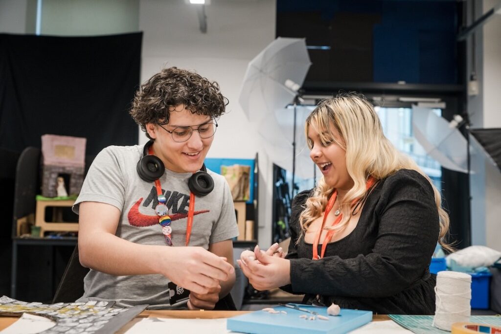 Two students working on a clay sculpture