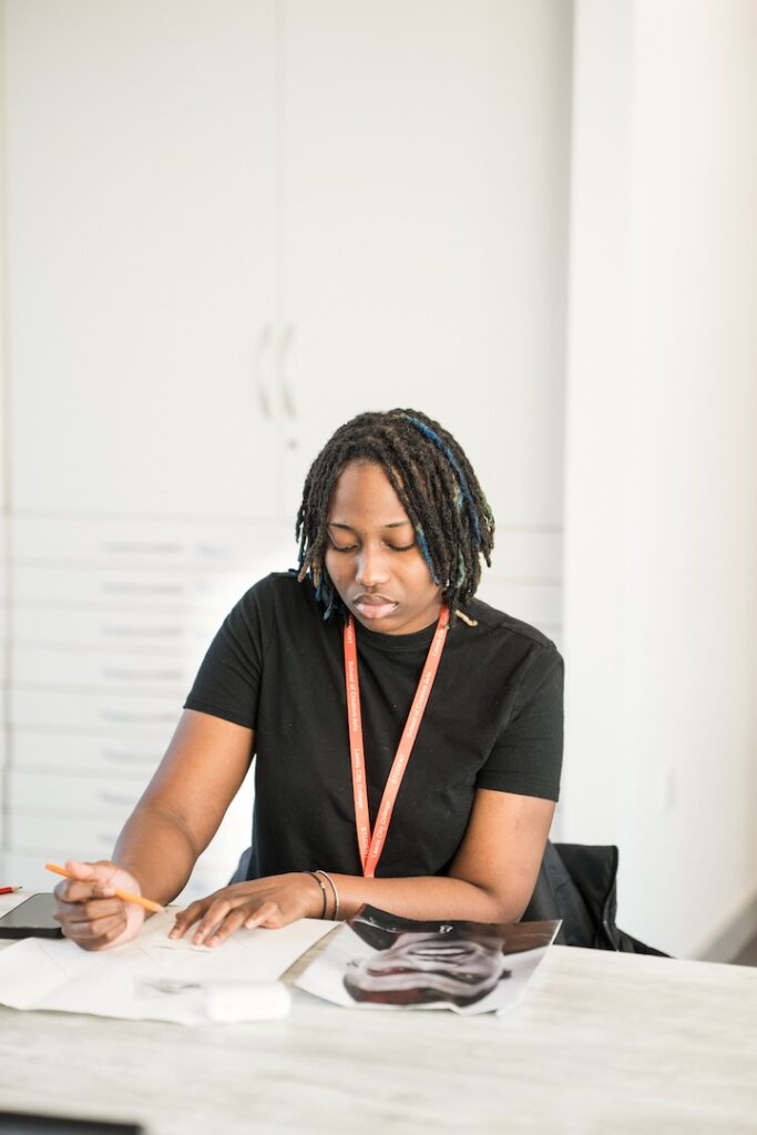 Student drawing a portrait from a picture reference