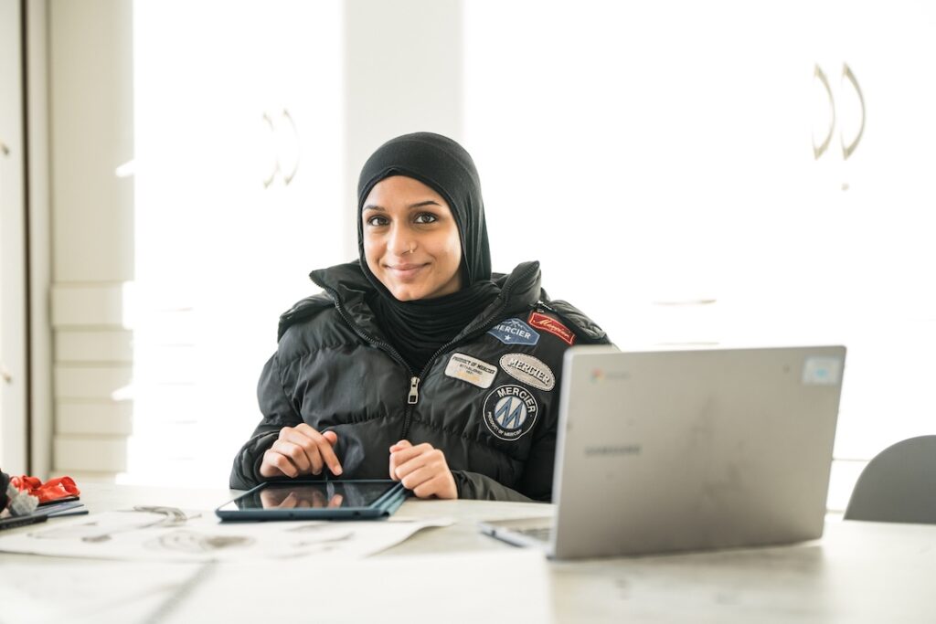 Student working on a tablet and laptop